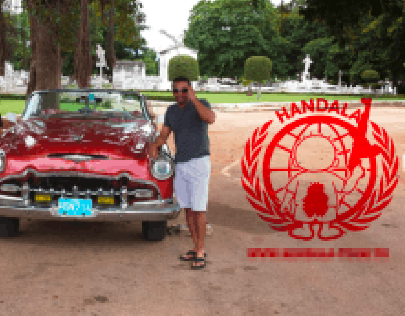 Patel standing beside an antique sports convertible
